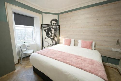 a bedroom with a large bed with pink pillows at Revolver Edinburgh in Edinburgh