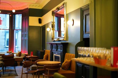 a restaurant with chairs and tables and a mirror at Revolver Edinburgh in Edinburgh