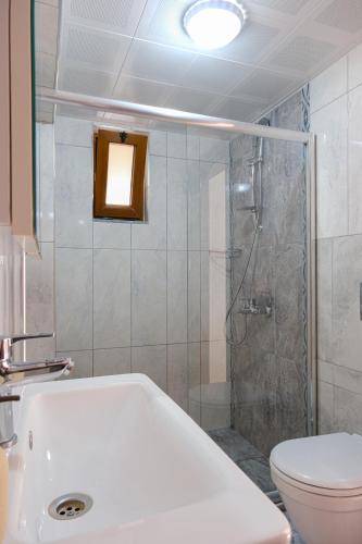 a bathroom with a shower and a toilet and a sink at The Place Boutique Hotel Kalkan in Kalkan