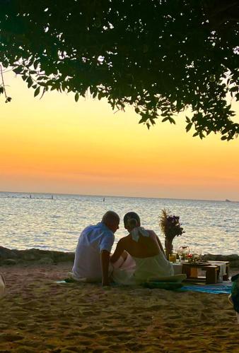a couple sitting on the beach watching the sunset at Thani Ecobeach Barú in Playa Blanca