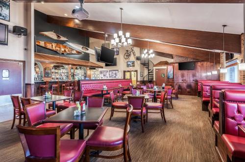 a restaurant with tables and chairs and a bar at Clarion Inn Harpers Ferry-Charles Town in Harpers Ferry