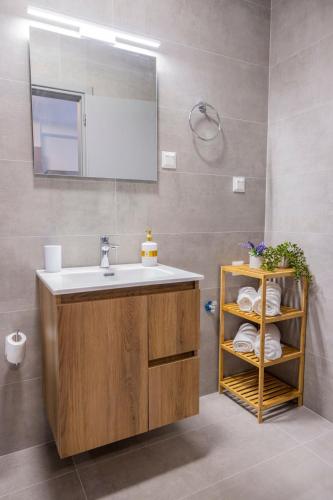 a bathroom with a sink and a mirror and towels at Peace Home Trikala in Tríkala