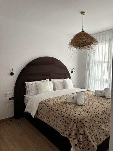 a bedroom with a large bed with a large headboard at Zazz Estepona in Estepona