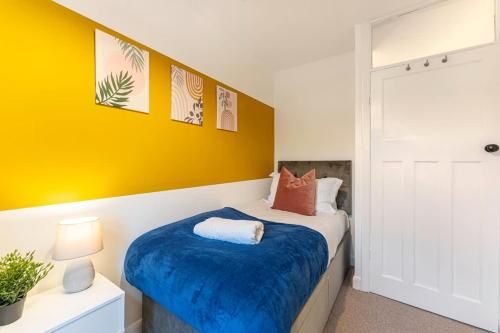 a bedroom with a bed with a blue blanket at Spacious 3-Bed with parking NEAR NEC & BHX AIRPORT in Allesley