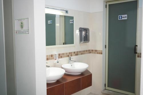a bathroom with two sinks and a mirror at Rolovi Hotel Xalapa Centro in Xalapa
