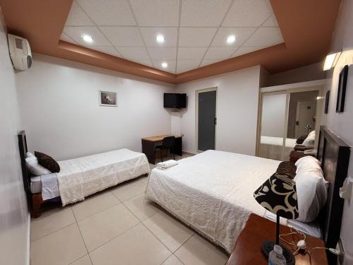 a hotel room with two beds and a television at Rolovi Hotel Xalapa Centro in Xalapa