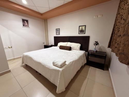 a bedroom with a large bed with a white blanket at Rolovi Hotel Xalapa Centro in Xalapa