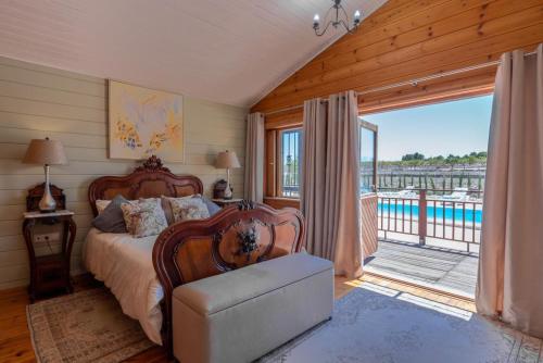a bedroom with a bed and a balcony with a pool at Rustic Villa Retreat in Pinoso