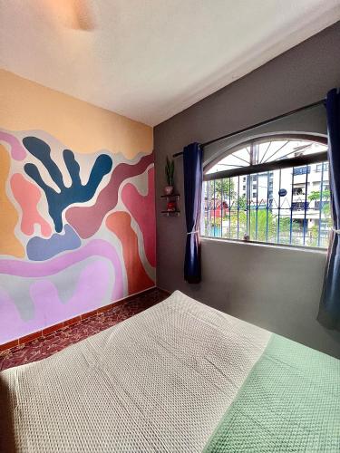 a bedroom with a bed and a window at Qué onda! in Ubatuba