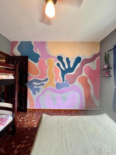 a bedroom with a painting on the wall at Qué onda! in Ubatuba