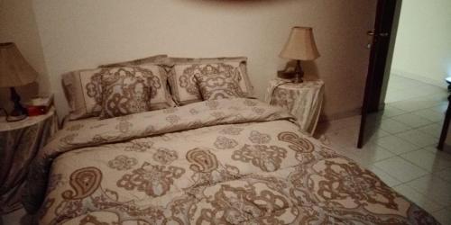 a bedroom with a bed and two tables with lamps at Beachside Vacation House in Ras al Khaimah
