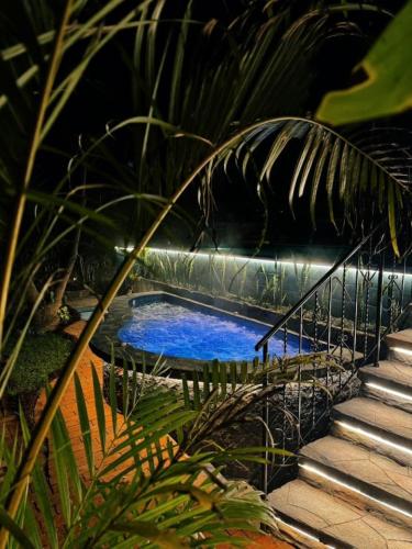 a small swimming pool in a garden with stairs at Private Room With Jacuzzi, Pool, and Sauna. in San Lucas Tolimán