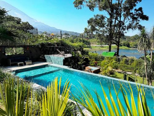 a swimming pool with a view of a river and mountains at Private Room With Jacuzzi, Pool, and Sauna. in San Lucas Tolimán