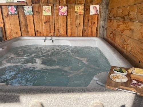 a jacuzzi tub with a tray of food in it at Lucky luke's hideaway in Heibloem