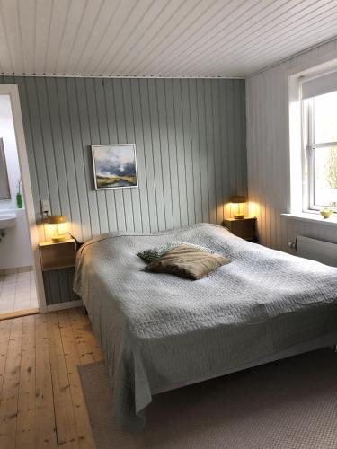 a bedroom with a bed and two lamps and a window at Heltoften Bed & Breakfast in Nykøbing Mors