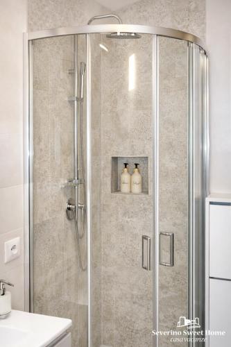 a bathroom with a shower with three bottles in it at Severino Sweet Home Casa Vacanze in Mercato San Severino