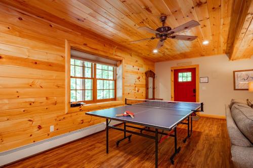 a ping pong table in a room with wooden walls at Tranquil Timber by Railey Vacations in Swanton