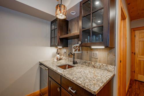 a kitchen with a sink and wooden cabinets at Tranquil Timber by Railey Vacations in Swanton