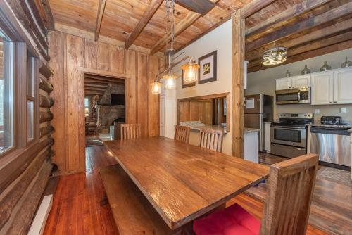 a dining room and kitchen with a large wooden table at Tolson Cabin by Railey Vacations in Oakland