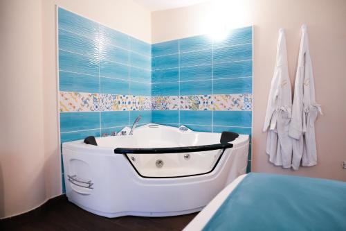 a bath tub in a bathroom with blue tiles at Rooms Vesuvio Est in Striano