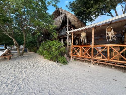 a house on the beach with a thatch roof at Thani Ecobeach Barú in Playa Blanca