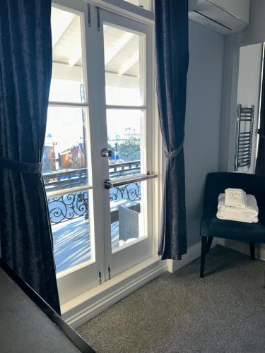 a room with a door with a window and a chair at The Royal Hotel - Clacton On Sea in Clacton-on-Sea