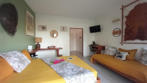 a bedroom with two beds and a couch at Studio tout confort - Hameka in Grand-Bourg