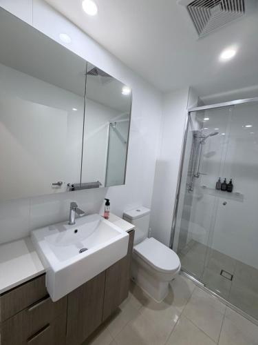 a bathroom with a sink and a toilet and a shower at 24 Bromley St private room in a luxurious shared apt in Brisbane