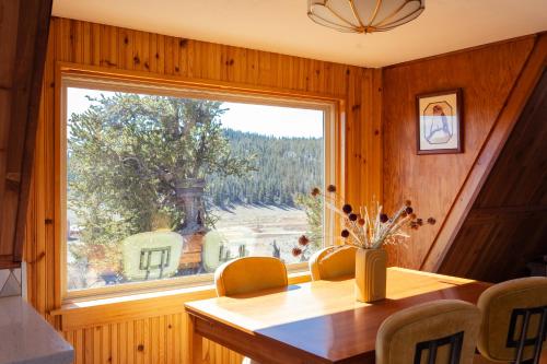 a dining room with a table and a large window at The Cozy Owl A-Frame in Jefferson