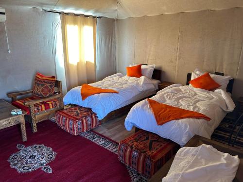 a room with two beds and a chair in it at Andromeda Desert Astro Camp in Tisserdmine