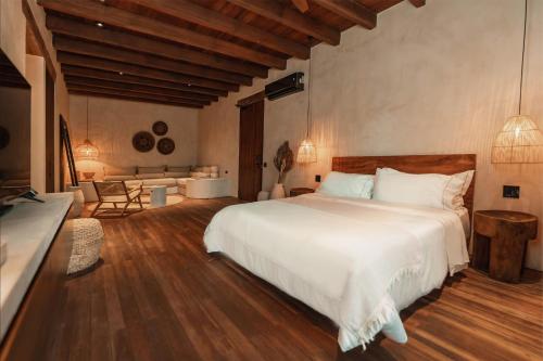a bedroom with a large white bed and wooden floors at Makani Luxury Cartagena in Tierra Bomba