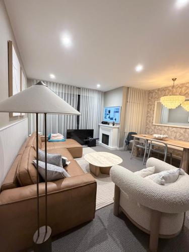 a living room with a couch and chairs and a table at 24 Bromley St private room in a luxurious shared apt in Brisbane