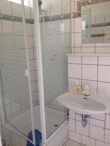 a white bathroom with a sink and a shower at Ferienwohnung Odessa in Zinnowitz