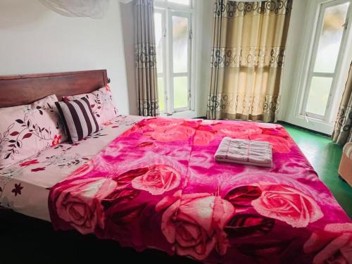 a bedroom with a pink bed with roses on it at Sisila villa ella in Ella