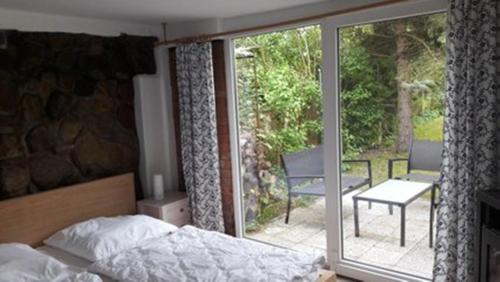 a bedroom with a bed and a view of a patio at Ferienhaus Ralf in Zinnowitz