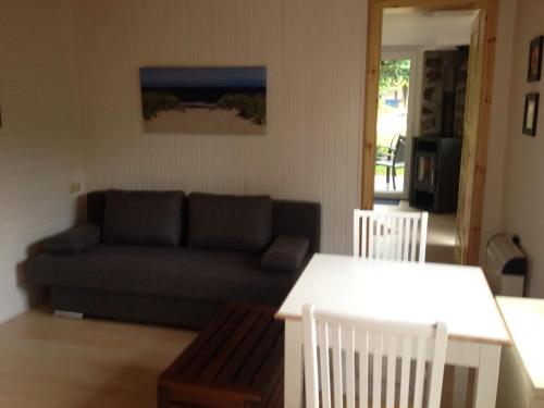 a living room with a couch and two white chairs at Ferienhaus Ralf in Zinnowitz