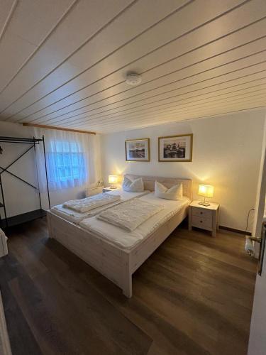 a bedroom with a large bed and two lamps at Ferienhaus Fischerhaus in Zinnowitz