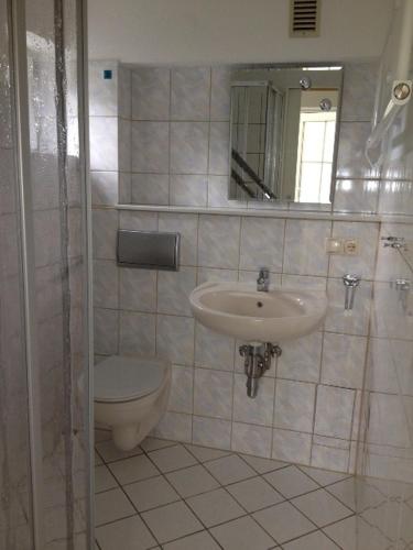 a bathroom with a sink and a toilet and a mirror at Ferienwohnung Johannes in Zinnowitz