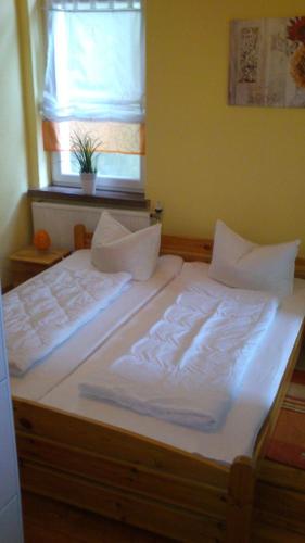a large white bed in a room with a window at Ferienwohnung Regina in Zinnowitz