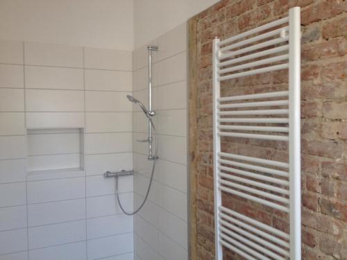 a bathroom with a shower with a brick wall at Ferienwohnung Regina in Zinnowitz