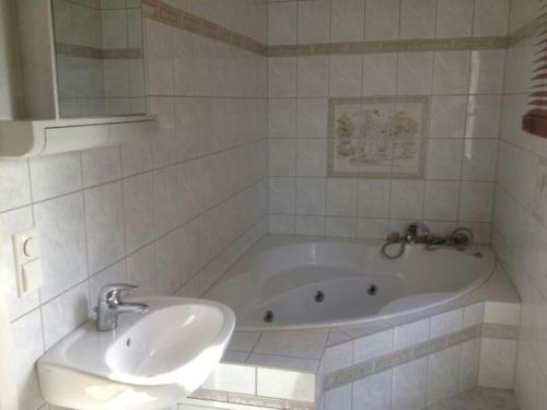 a white bathroom with a tub and a sink at Ferienwohnung Klabautermann in Zinnowitz