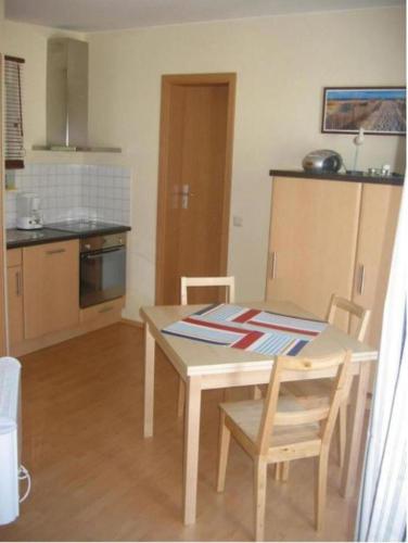 a kitchen with a table and chairs in a room at Ferienhaus Alessandra in Zinnowitz