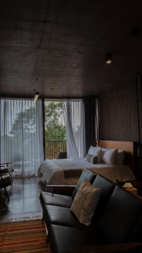 a large bedroom with two beds and a couch at Casa de Agua in Tepoztlán