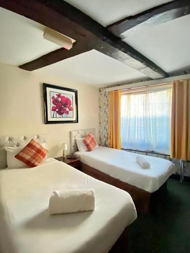 a hotel room with two beds and a window at Greyfriars Lodge Canterbury in Canterbury