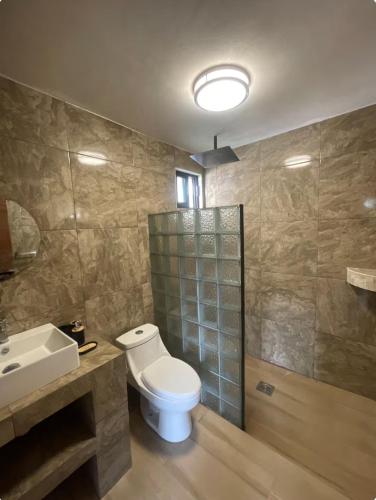 a bathroom with a toilet and a sink at Cabañas Los Angeles in Valle de Bravo
