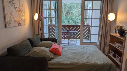 a living room with a bed and a couch at Cosy MO-MAÂ Golf, Océan et Plages in Moliets-et-Maa