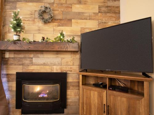 a living room with a flat screen tv and a fireplace at Silverado I Building B Unit 204 in Winter Park