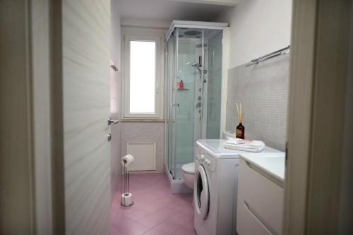 a bathroom with a toilet and a sink and a washing machine at L'arco Sul Mare in Balestrate