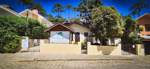 a building with a sign in front of it at A Nossa Casinha Capivari - 400m do Parque Capivari in Campos do Jordão