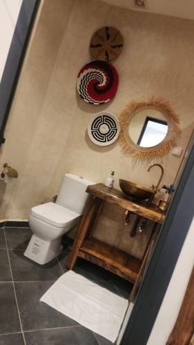 a bathroom with a toilet and a sink and mirrors at La Perle Ourika Valley Guest House in Ourika